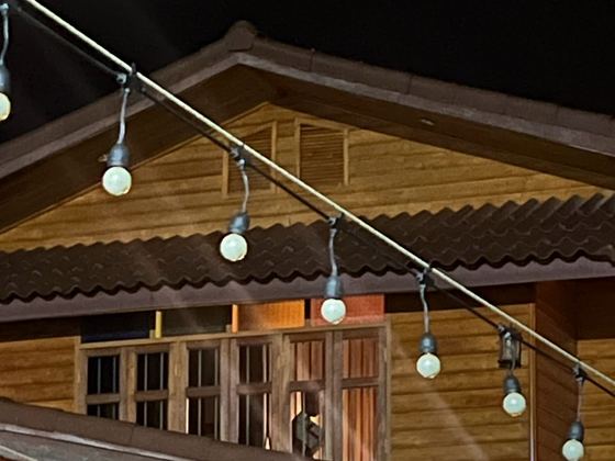 ไฟประดับหน้าบ้านไม้ตอนกลางคืน / String lights on the wooden house at night